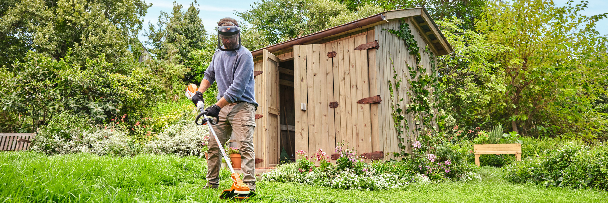  Un hombre recorta la hierba con la desbrozadora de batería STIHL FSA 70 R