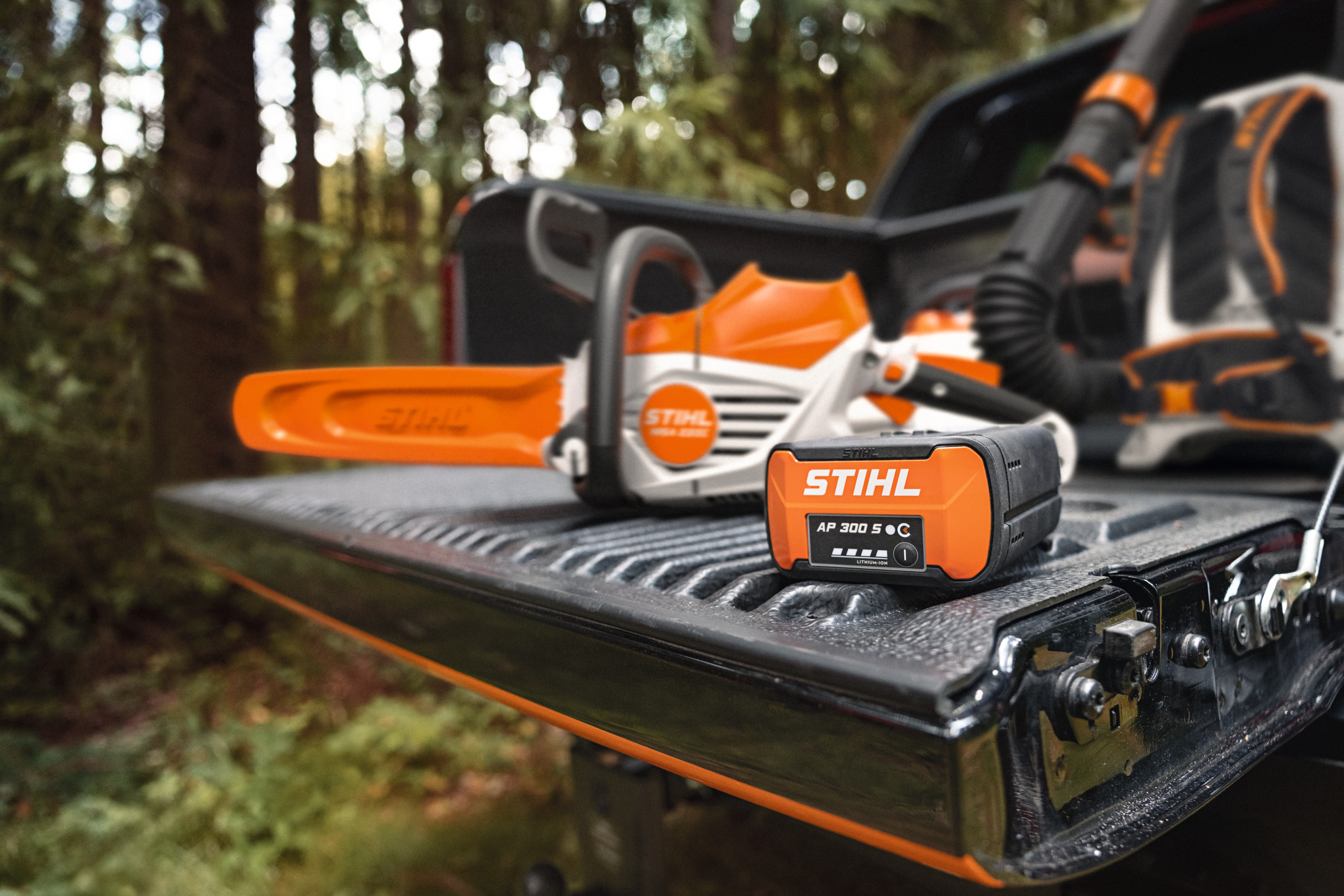 Batería STIHL AP 300 S en la superficie de carga de una pickup junto con la nueva motosierra de batería STIHL MSA 300