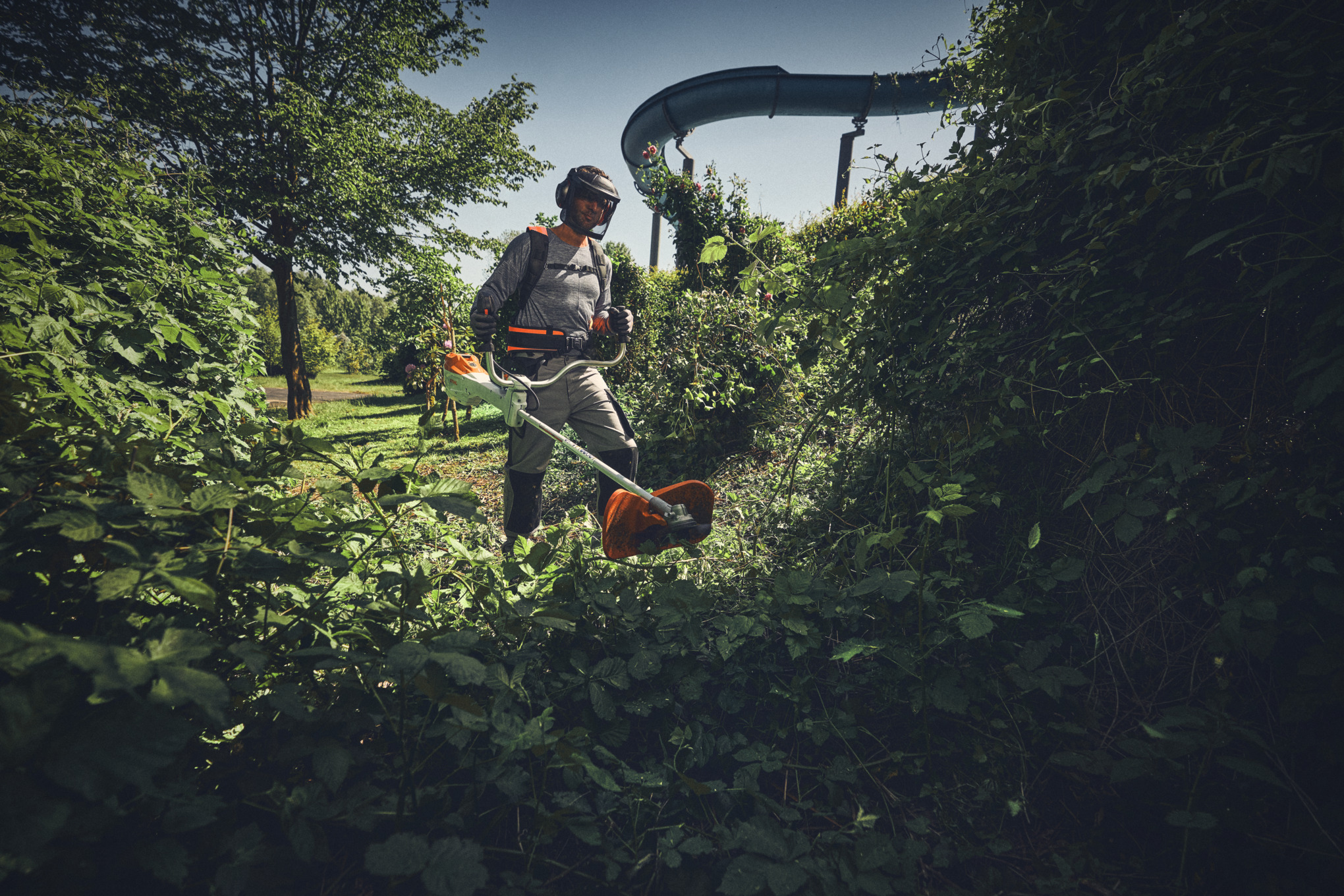Un hombre con una desbrozadora de batería STIHL FSA 400 cortando maleza - Campaña de Primavera de 2025 para profesionales