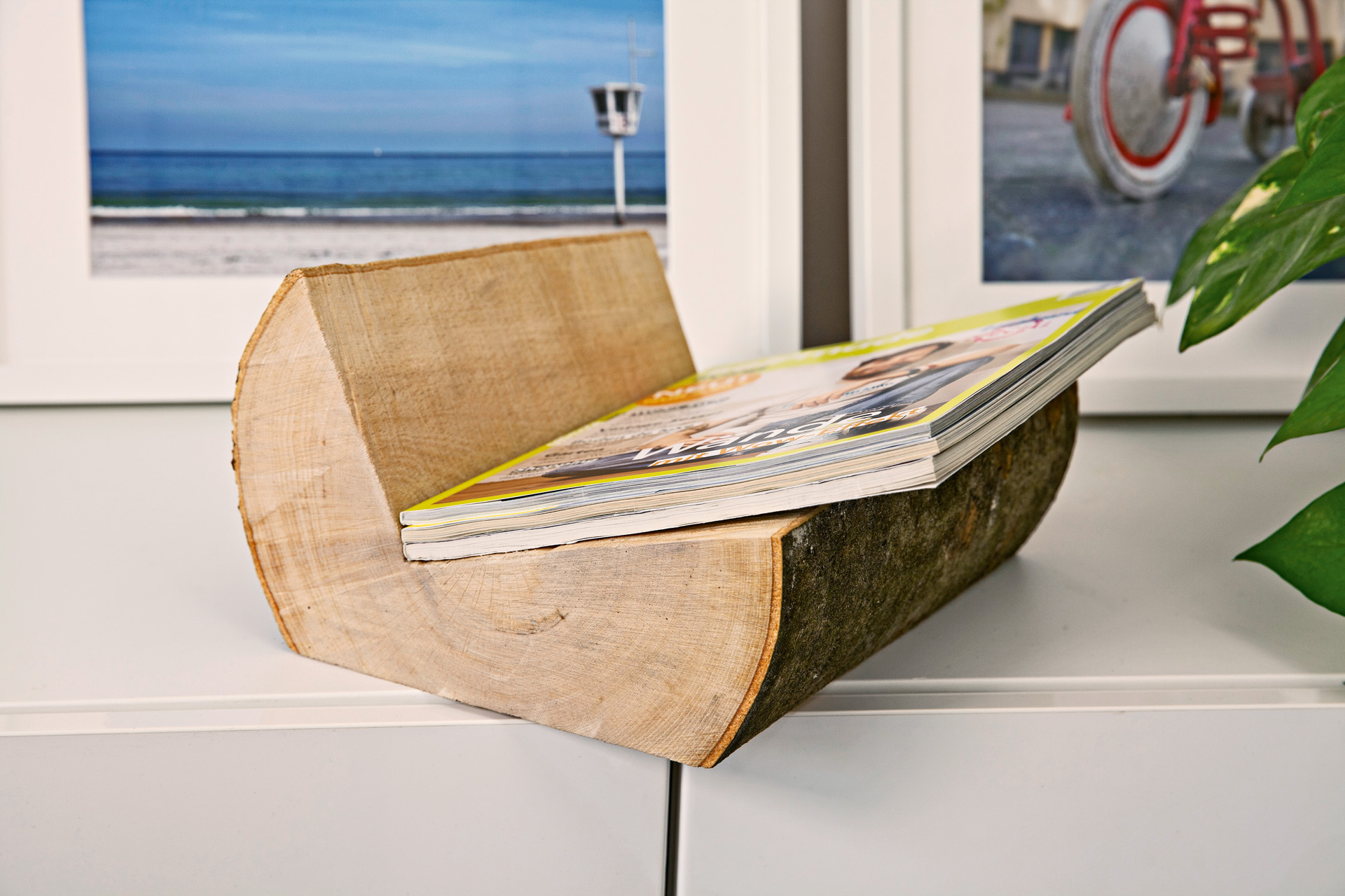 Unas revistas situadas en un revistero DIY hecho a partir de un tronco.