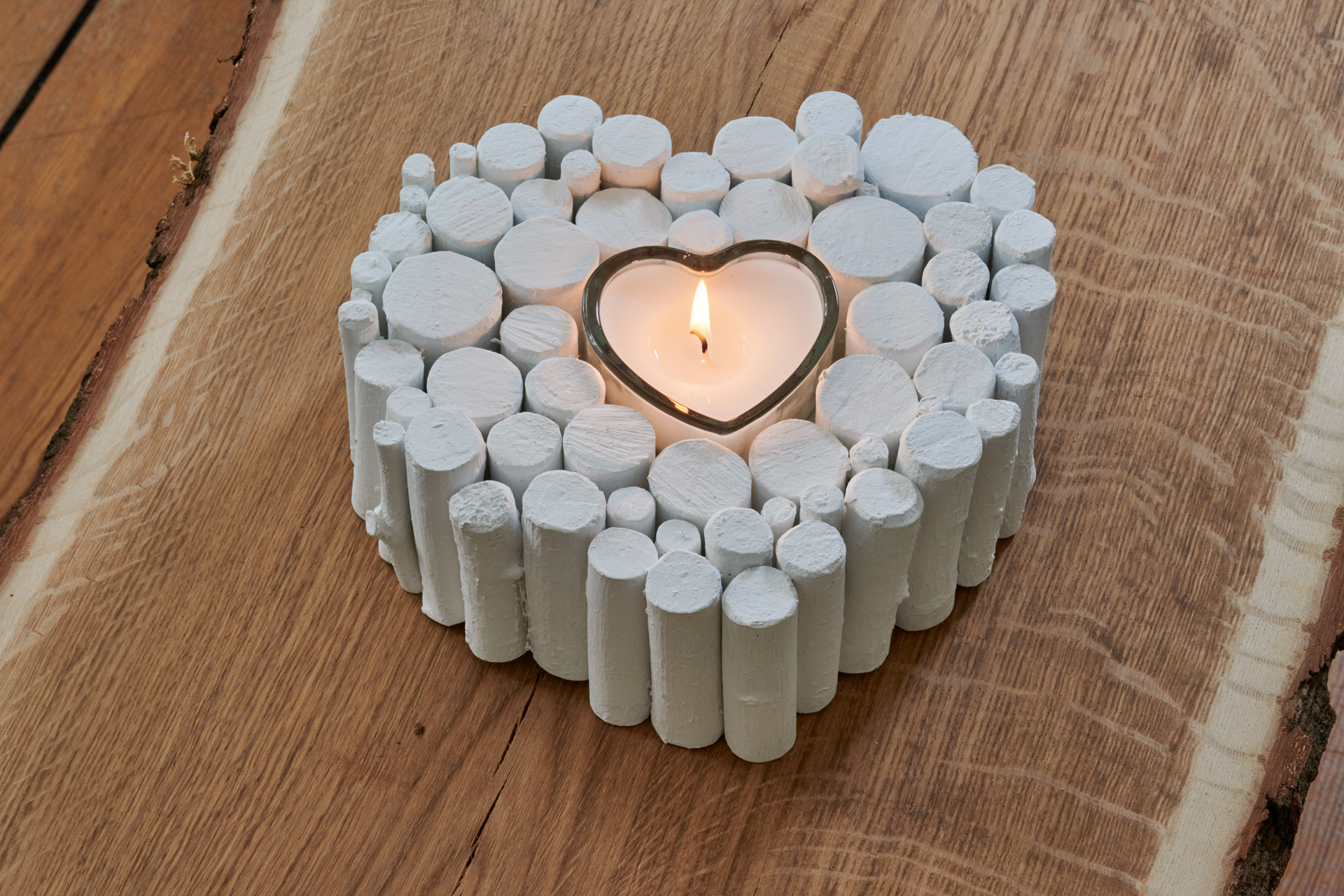 Crea tu corazón de ramas: adorno acabado pintado de blanco con una vela encendida en su interior.