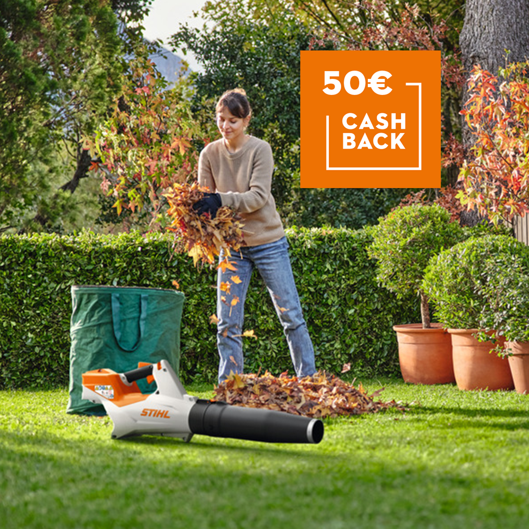 Una mujer recoge hojas de su jardín con la ayuda del un solador de batería STIHL