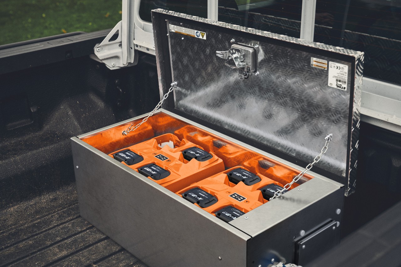 Estación de carga STIHL CB 1 con baterías ALLPRO en la caja de carga de una camioneta