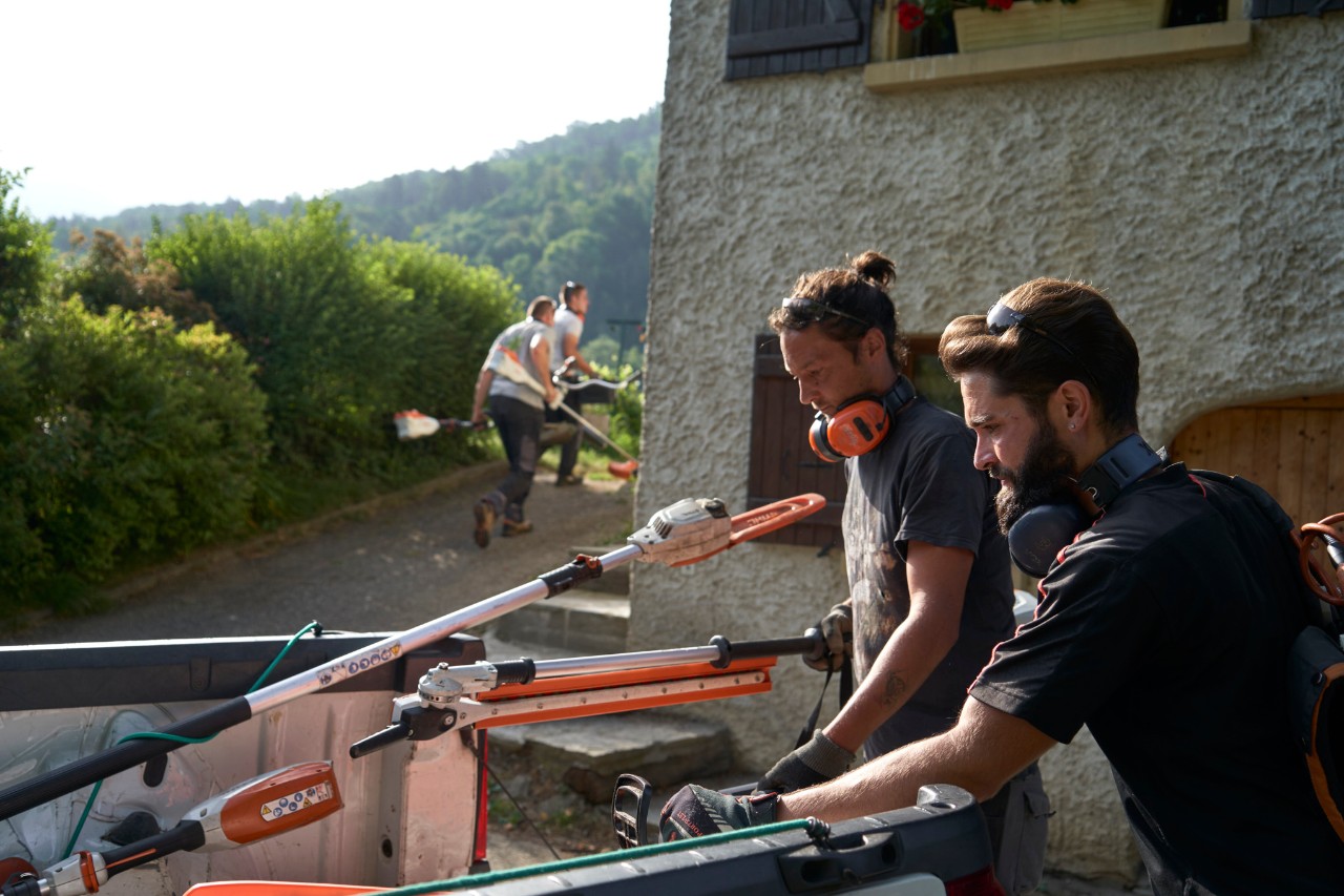 Julien Loquarelli, jardinero paisajista, descarga el equipo STIHL del vehículo junto con sus compañeros de trabajo.